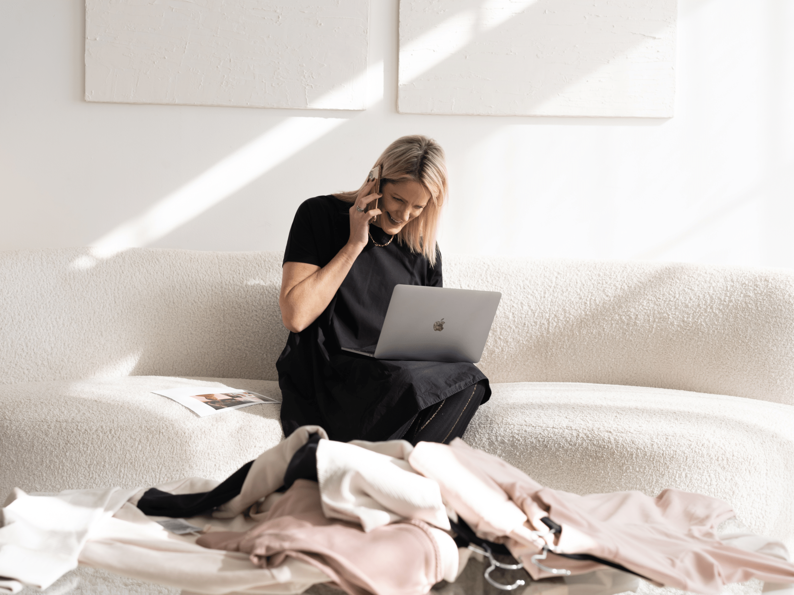 Kirsten K. Harris working through a client conversation with laptop and phone in soft natural light