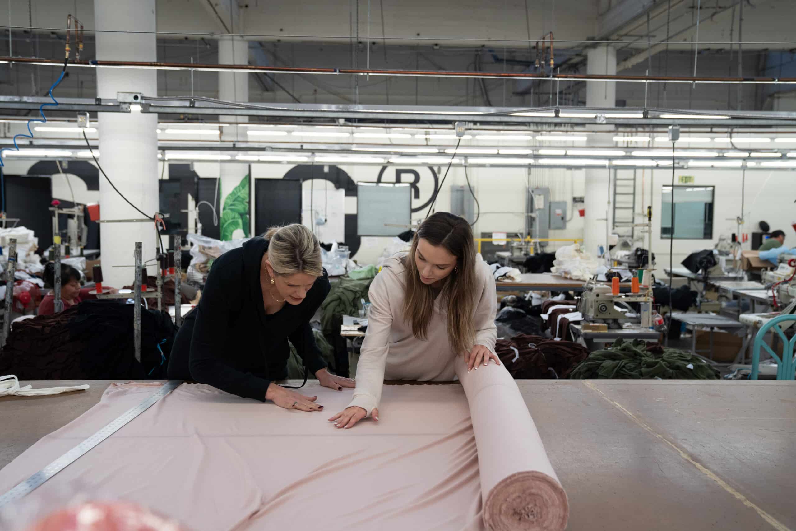 Reviewing fabric on the cutting table inside a working garment factory